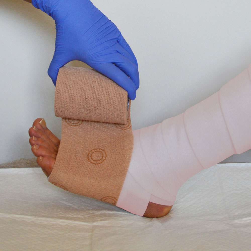 Image of a foot being wrapped with a compression bandage wound dressing